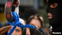 FILE - A member of Iran's special police forces checks the rope before an execution by hanging, in Tehran, Aug. 2, 2007. 
