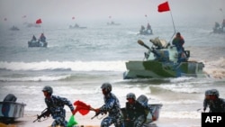 资料照片：官方公布的图像显示，中国两栖坦克与士兵参加在山东举行的登陆军演。（2005年8月24日）