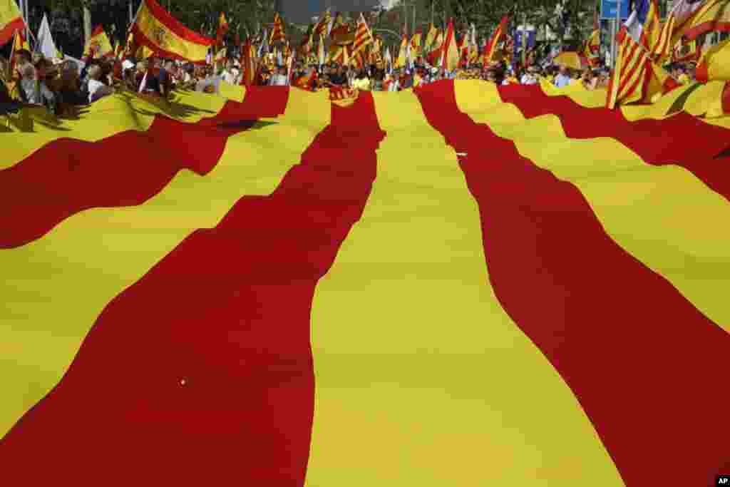 Para aktivis nasionalis Spanyol melakukan unjuk rasa dengan membawa bendera raksasa Catalan untuk menentang deklarasi kemerdekaan Catalonia di Barcelona, Spanyol.