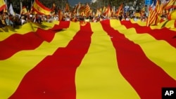 Activists protest with a giant Catalan flag during a mass rally against Catalonia's declaration of independence, in Barcelona, Spain, Oct. 29, 2017. 