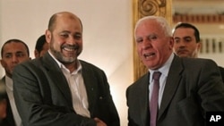 Palestinian Fatah delegation chief Azzam al-Ahmed (R) shakes hands with Hamas deputy leader Mussa Abu Marzuq after a joint press conference in Cairo, Egypt, April 27, 2011