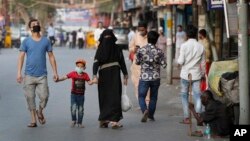 Keluarga Muslim India pulang ke rumah setelah berbelanja saat tiga jam jeda pembatasan jarak aman, di New Delhi, India, 25 April 2020.