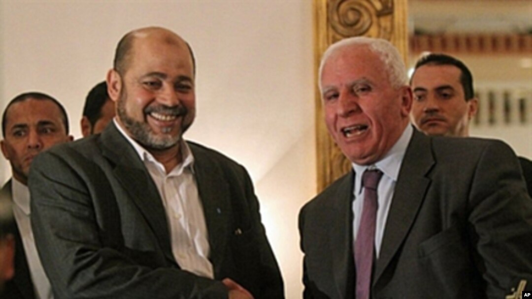 Palestinian Fatah delegation chief Azzam al-Ahmed (R) shakes hands with Hamas deputy leader Mussa Abu Marzuq after a joint press conference in Cairo, Egypt, April 27, 2011
