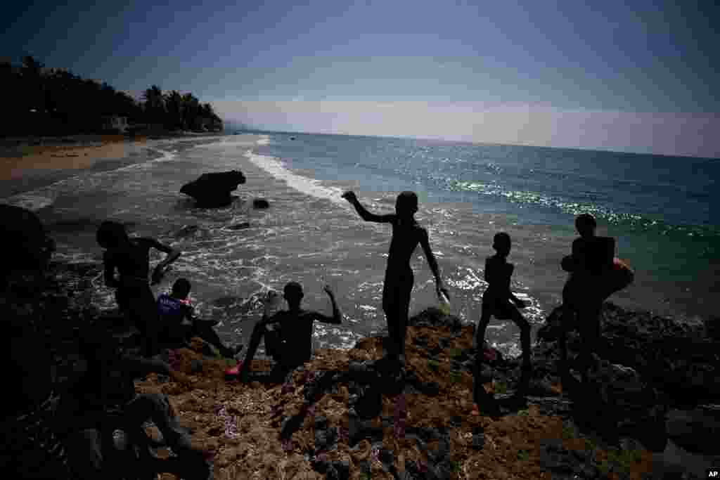 Boys are fish on the coast near Jacmel, Haiti, Oct. 6, 2019.