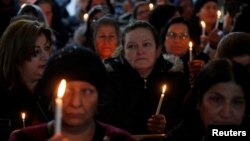 FILE - Iraqi Christians attend a Mass on Christmas eve at the Mar Shimoni church in the town of Bartella, east of Mosul, Dec. 24, 2016. 