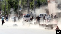 Security forces run from the site of a suicide attack after the second bombing in Kabul, Afghanistan, April 30, 2018.