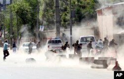 Security forces run from the site of a suicide attack after the second bombing in Kabul, Afghanistan, Monday, April 30, 2018.