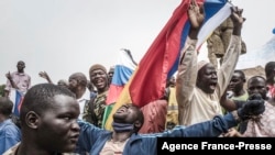 FILE - Protesters wave Russian and Malian flags in Bamako, during a demonstration against French influence in the country, May 27, 2021. Russian soldiers have deployed to Timbuktu to train Malian forces, the Malian army said Jan. 6, 2022.