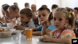 Anak-anak dari panti asuhan makan bersama di sebuah kamp di Zolotaya Kosa, pemukiman di Laut Azov, wilayah Rostov, Rusia barat daya (foto: ilustrasi). 