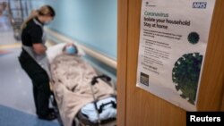 Seorang petugas ambulans berbicara kepada seorang pasien non-Covid-19 sebelum memindahkannya dari rumah sakit ke sebuah panti jombo di Portsmouth, Inggris, 5 Mei 2020. 