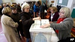 A woman casts her ballot at the first round for the French left's presidential primaries ahead of the 2017 presidential election, in Marseille, southern France, Jan.22, 2017.