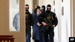 Policemen escort Salih Muslim, former co-chair of the Democratic Union Party, or PYD, to a court room for a custody hearing in Prague, Czech Republic, Tuesday, Feb. 27, 2018.