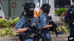 (FILE) Armed police stand guard outside the West Kowloon Magistrates' Courts in Hong Kong, Wednesday, Nov. 20, 2024.