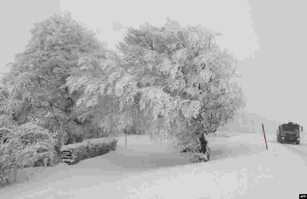 A truck makes its way through the snowy landscape on the Schauinsland mountain in the Black Forest, southern Germany.