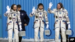 U.S. astronaut Donald Pettit (L), Russian cosmonaut Oleg Kononenko (C) and Dutch astronaut Andre Kuipers, members of the International Space Station (ISS) crew, wave before the launch of the Soyuz TMA-03M spacecraft at Baikonur cosmodrome, December 21, 20