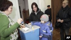 People cast their votes at a polling station during Estonia's general elections in Abja, March 6, 2011