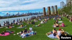 People try to keep social distance as they enjoy a warm day during the outbreak of the coronavirus disease (COVID-19) at Domino Park in Brooklyn, New York, U.S., May 16, 2020. 