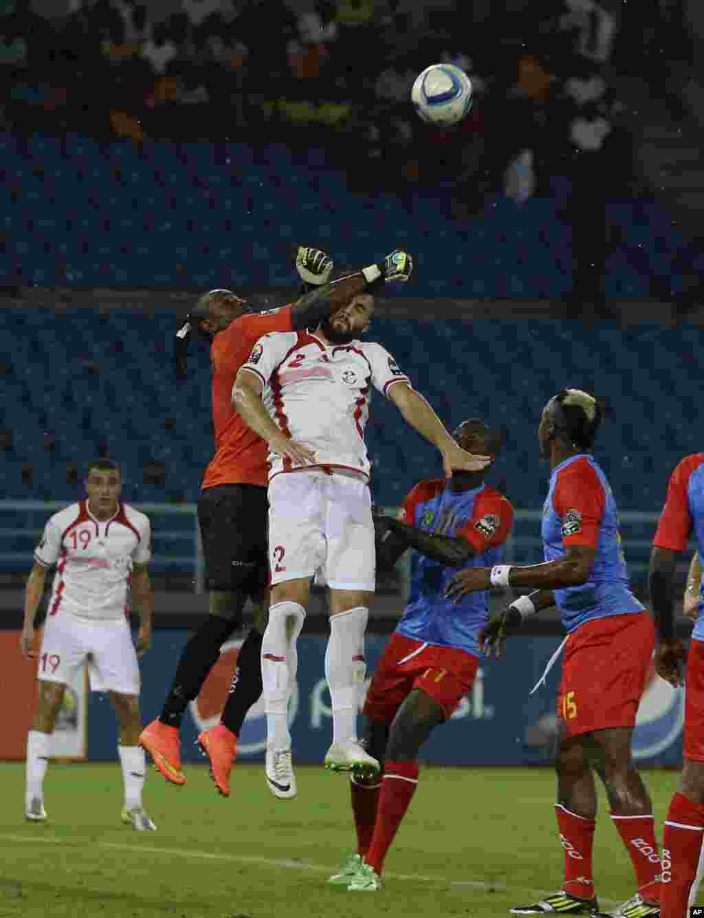 Syam Youssef de la Tunisie, en haut à droite, est battu dans un duel aérien par le gardien de but de la RD Congo Robert Muteba Kidiaba, en haut à gauche, lors de leur match de la CAN Groupe B à Bata, en Guinée équatoriale, lundi 26 janvier 2015.