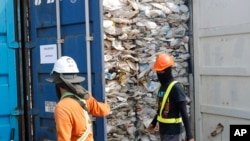 Pekerja membuka kontainer penuh plastik yang tidak dapat didaur ulang, yang ditahan oleh pihak berwenang di pelabuhan barat di Klang, Malaysia, Selasa, 28 Mei 2019. (Foto: dok).
