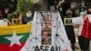 Activists display posters and defaced portraits of Myanmar's Commander-in-Chief Senior General Min Aung Hlaing during a rally against the military coup in Jakarta, Indonesia, April 24, 2021. 