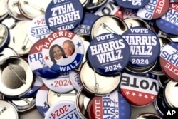 Campaign pins for sale are pictured before a rally for Democratic presidential nominee Vice President Kamala Harris at the Dort Financial Center in Flint, Michigan, Oct. 4, 2024.