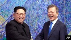 Pemimpin Korut Kim Jong-un (kiri), berpose dengan Presiden Korsel Moon Jae-in di desa perbatasan Panmunjom, di Zona Demiliterisasi, Korea Selatan, 27 April 2018. (Foto: dok).