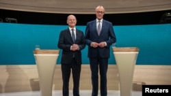 Kanselir Olaf Scholz dan rivalnya dari kubu konservatif, Friedrich Merz, berpose menjelang debat antar kedua tokoh politik tersebut di Berlin, Jerman, pada 9 Februari 2025. (Foto: Michael Kappeler/Pool via Reuters)