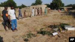 FILE - People gather at the site of a suicide attack in Maiduguri, Nigeria, Nov. 16, 2017. 