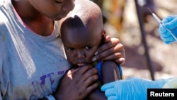 Monganga azali kopesa mangwele ya Ebola na mwana moko na Goma, Nord-Kivu, 5 aout 2019.