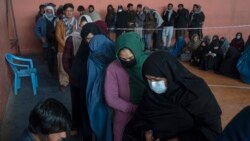 People wait to receive money at a center organized by the World Food Program in Kabul, Afghanistan on November 17, 2021. With the U.N. warning millions are near-famine, the WFP has greatly increased direct aid to families. (AP Photo/Petros Giannakouris)