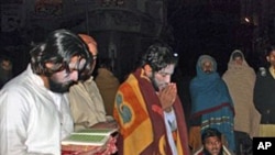 People read verses of the Quran while gathering with others outside their homes in Quetta, Pakistan, after a severe earthquake hits the area, Jan 18 2011