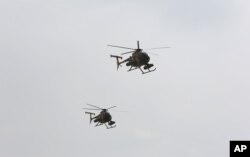 FILE - U.S.-made MD-530 Helicopters fly over the Hamid Karzai International Airport during a display of newly-delivered assets by the Afghan Air Force in Kabul, Afghanistan, Feb. 11, 2016. Afghanistan's air force is said to soon receive up to 200 helicopters and other aircraft.