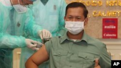 FILE - Cambodia's Lt. Gen. Hun Manet, a son of Prime Minister Hun Sen, thumbs up as he receives a shot of the COVID-19 vaccine at Calmette hospital in Phnom Penh, Cambodia, Wednesday, Feb. 10, 2021. (AP Photo/Heng Sinith)