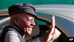 FILE - South African Anglican Archbishop Emeritus Desmond Tutu, center, waves after voting during municipal elections in Cape Town, South Africa, Wednesday, Aug. 3, 2016.