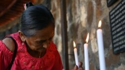 Una mujer enciende una vela en conmemoración de la masacre de El Mozote. Más de 75,000 personas fueron asesinadas o desaparecieron durante la guerra civil de El Salvador.