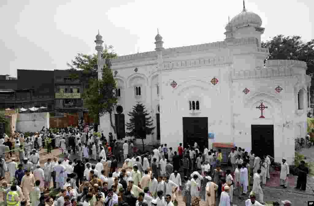 People gather at the site of a suicide attack on a church in Peshawar, Pakistan, Sept. 22, 2013.