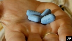 FILE - A doctor holds Truvada pills at her office in San Francisco, May 10, 2012. New research shows more promise for using AIDS treatment drugs, such as Truvada, as a prevention tool, to help keep uninfected people from catching HIV during sex with a partner who has the virus. 