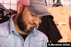 Sammy sells children's clothes in his stall in a market in Tripoli, Libya. He says his alliance is with peace, not with any government, April 30, 2019.