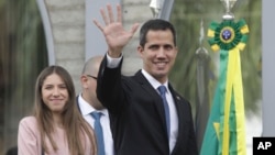 Venezuela's self-proclaimed interim president Juan Guaido waves at the press as he arrives for a meeting with ambassadors and representatives from European Union, in Brasilia, Brazil, Feb. 28, 2019. 