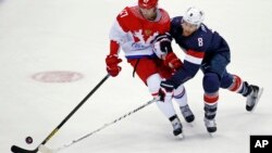 Russia forward Alexander Radulov and USA forward Joe Pavelski fight for the puck in the first period of a men's ice hockey game at the 2014 Winter Olympics, Feb. 15, 2014, in Sochi, Russia. 