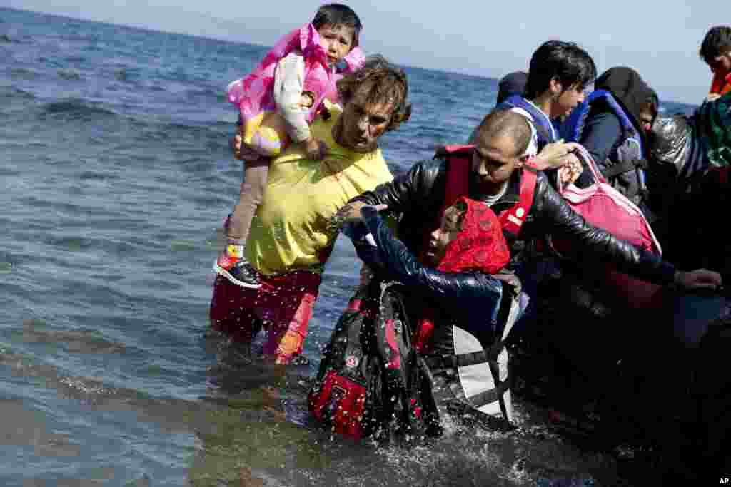 Afghan migrants arrive on the shores of the Greek island of Lesbos after crossing the Aegean sea from Turkey on a inflatable dinghy.