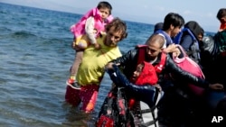 Afghan migrants arrive on the shores of the Greek island of Lesbos after crossing the Aegean sea from Turkey on a inflatable dinghy, Sept. 25, 2015.