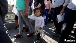 Las familias migrantes de México, huyendo de la violencia, ingresan a los Estados Unidos para reunirse con oficiales de Aduana y Protección Fronteriza de los EE. UU. para solicitar asilo en el puente fronterizo internacional Paso del Norte en Ciudad Juárez, junio 20, 2018.