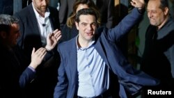 Head of radical leftist Syriza party Alexis Tsipras waves while leaving the party headquarters after winning the elections in Athens, January 25, 2015. Greek leftist leader Tsipras hailed the projected victory of his anti-austerity Syriza party in Sunday'