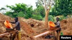 FILE - Gold miners sift through sandy soil as they work at an excavation site at a small scale mine in Bugiri, 348 km (216 miles) east of Kampala, Uganda's capital, Feb. 5, 2013. 