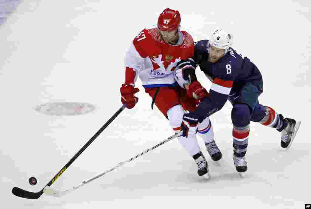 Russia forward Alexander Radulov and USA forward Joe Pavelski fight for the puck in the first period of a men's ice hockey game at the 2014 Winter Olympics, Feb. 15, 2014, in Sochi, Russia. 