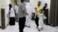 In this May 12, 2020 photo, Yemeni medical workers wearing masks and protective gear talk to patients at hospital in Aden, Yemen. People have been dying by the dozens each day in southern Yemen's main city, Aden, many of them with breathing difficulties,…