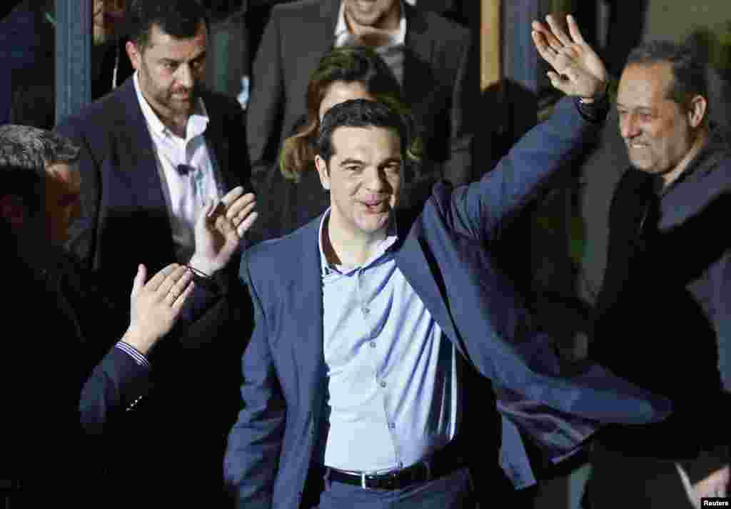 Head of radical leftist Syriza party Alexis Tsipras waves while leaving the party headquarters after his election victory, in Athens, Jan. 25, 2015.
