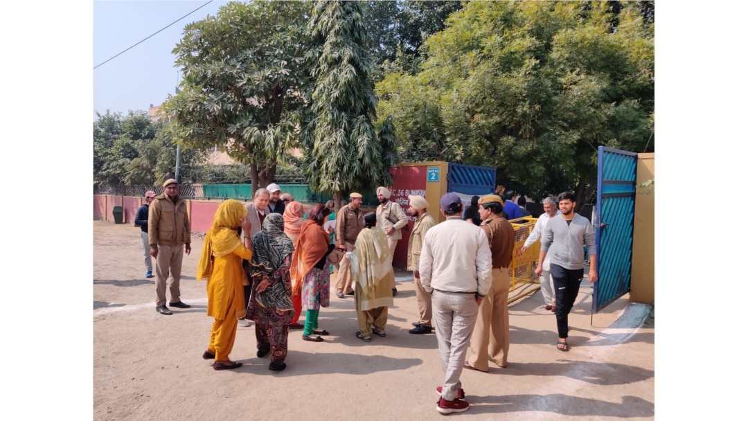 Voters enter a polling booth guarded by police as Delhi votes to choose a new state government, New Delhi, India, Feb. 8, 2010. (A. Pasricha/VOA)