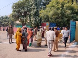 Voters enter a polling booth guarded by police as Delhi votes to choose a new state government, New Delhi, India, Feb. 8, 2010. (A. Pasricha/VOA)